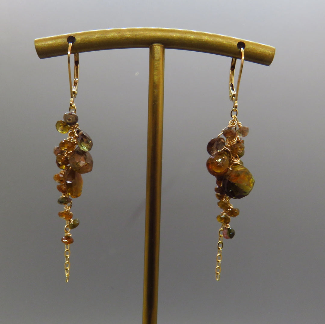 brown, copper, green andalusite gemstones dangle from gold chain in a cluster with gold leverbacks