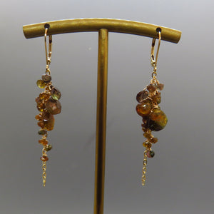 brown, copper, green andalusite gemstones dangle from gold chain in a cluster with gold leverbacks