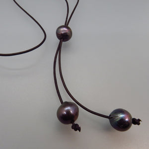 three large black peacock pearls on dark brown leather cord lariat style necklace