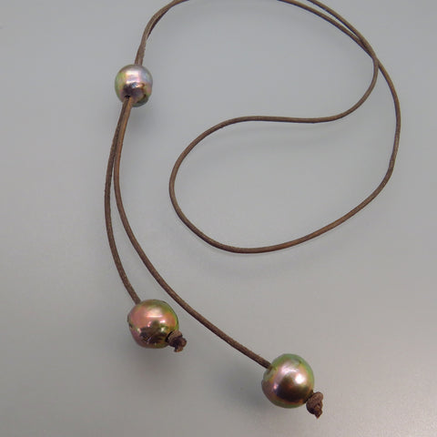 three gray freshwater pearls strung on light borwn leather cord lariat style necklace