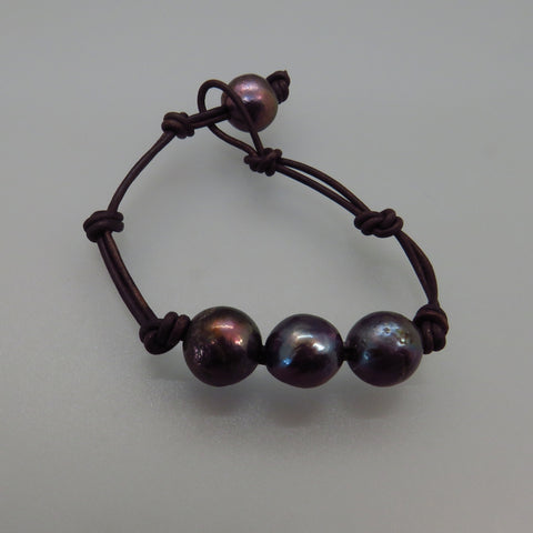 three black freshwater pearls on brown leather cord bracelet with additional pearl as toggle 