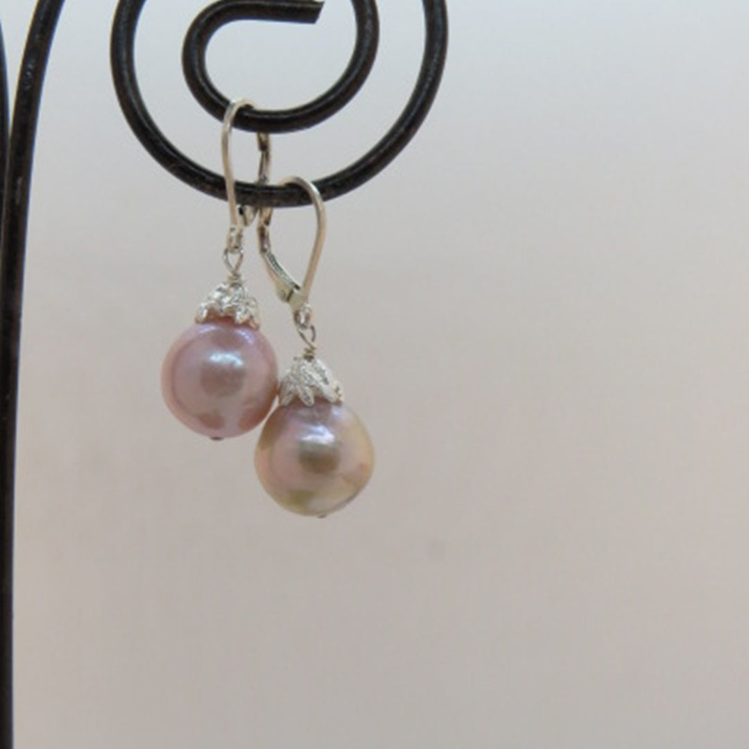 glowing pink lavender pearl earrings with silver flower caps and leverback ear wires