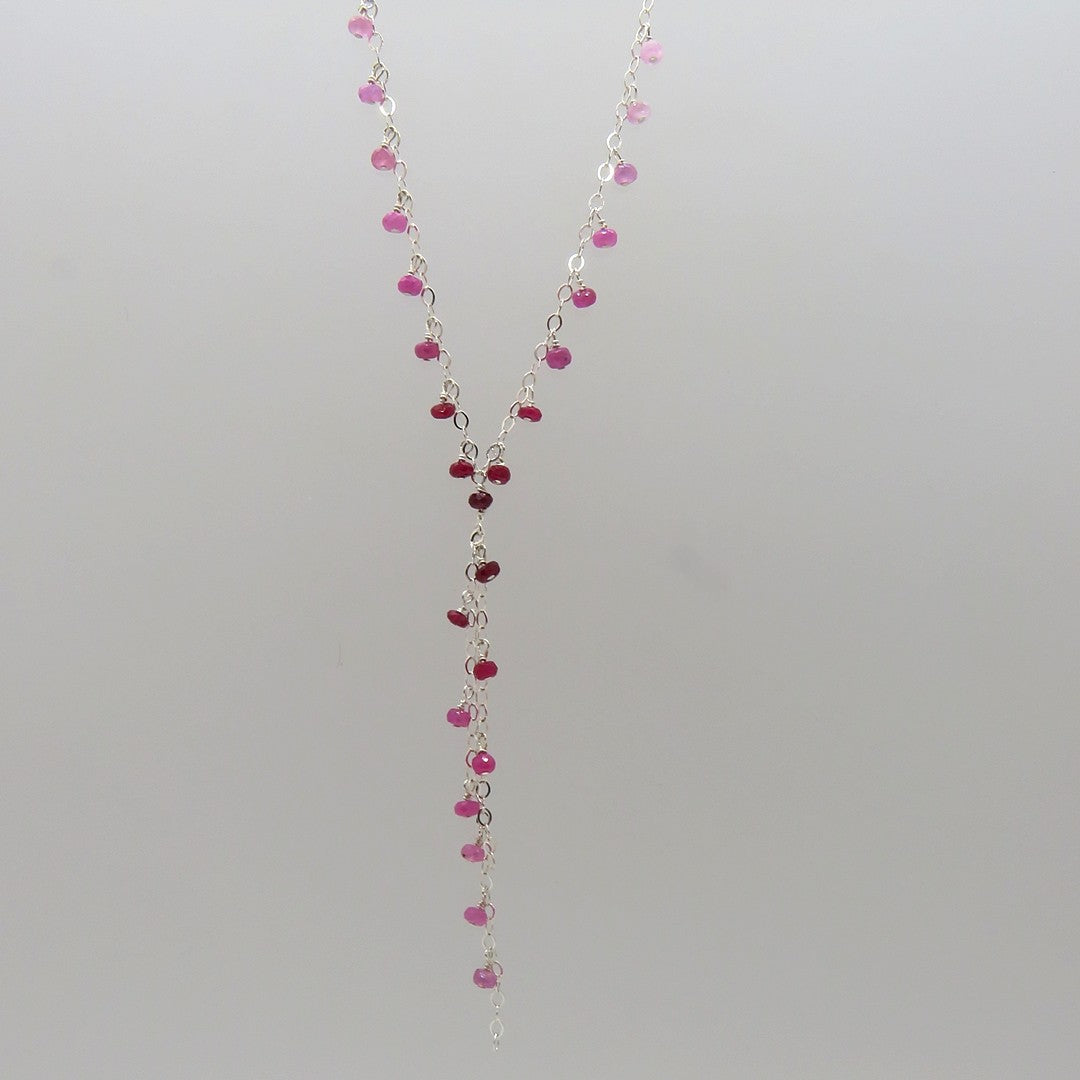 small faceted pink and red rubies dangle on silver chain, y necklace