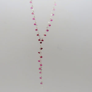 small faceted pink and red rubies dangle on silver chain, y necklace