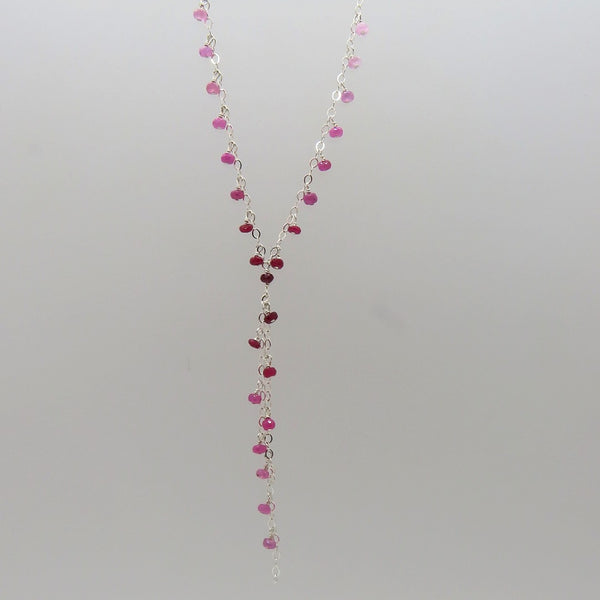 small faceted pink and red rubies dangle on silver chain, y necklace