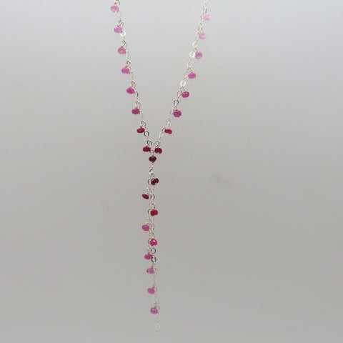 small faceted pink and red rubies dangle on silver chain, y necklace