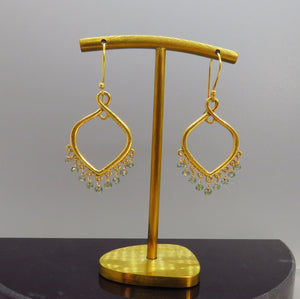 tiny green sapphires dangle from gold chandeliers