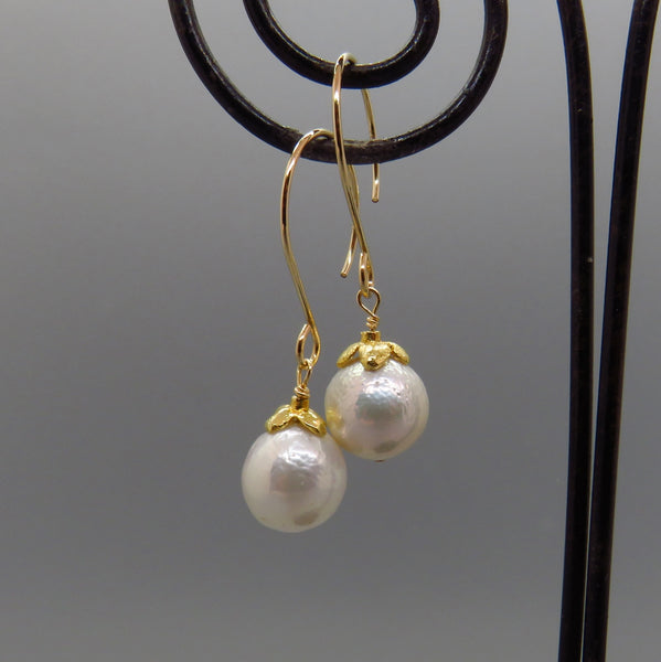 glowing white Edison pearl earrings capped with small flower and artisan ear wires