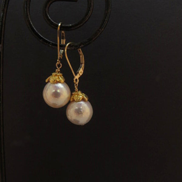 glowing white pearl earrings with gold flower cap and leverback ear wires